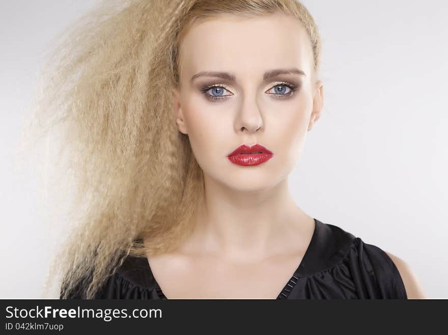 Young pretty woman with beautiful blond hairs and multicolor makeup on white background