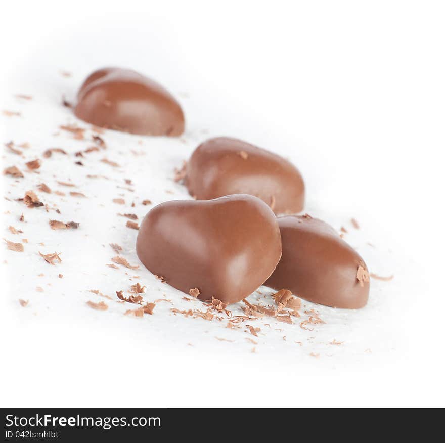 Chocolate hearts and chips on white background.