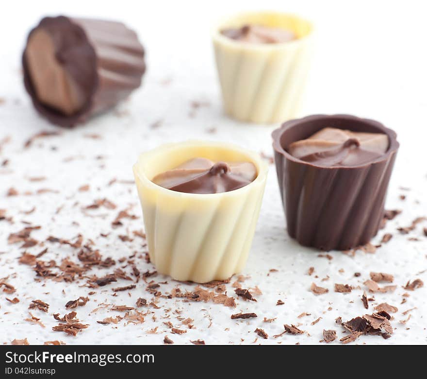 Chocolate baskets and chips on white background.