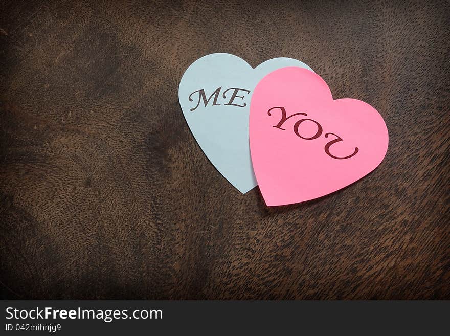 Heart shaped post its on wooden background