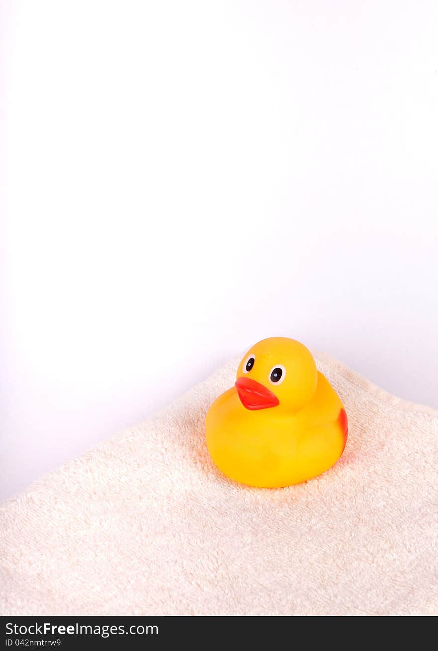 Rubber duck on white towel on white