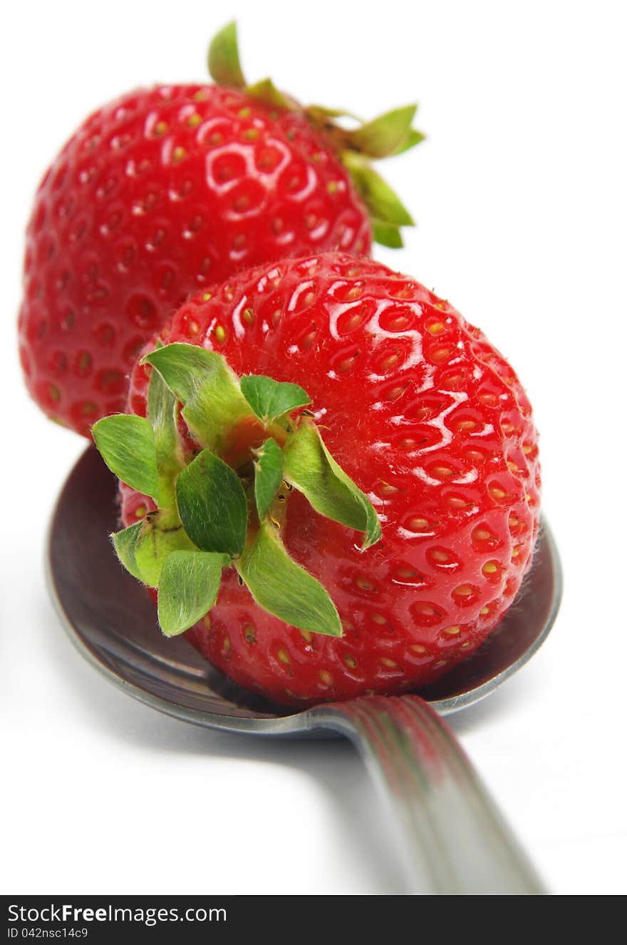 Strawberry closeup on the spoon over white. Strawberry closeup on the spoon over white