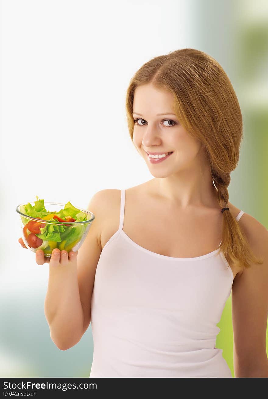 Beautiful young woman with vegetarian salad