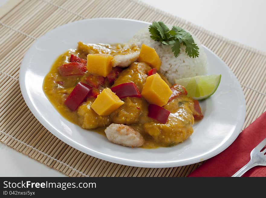 Spicy Thai mango chicken with red peppers, rice and lime