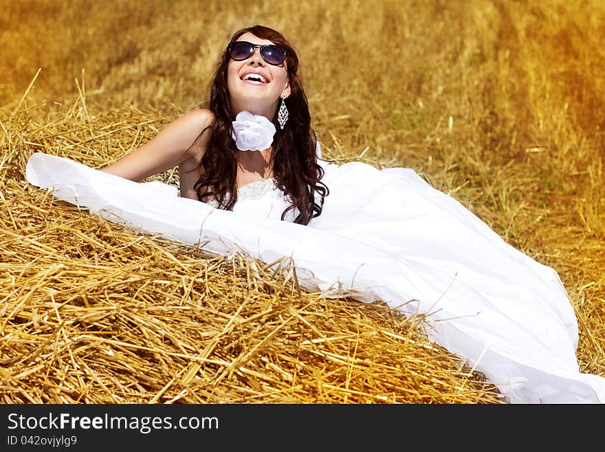 Bride relaxing in hay stack