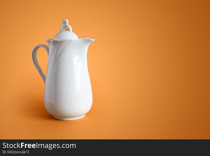 White ceramic milk jug on nice brown background with free space for text