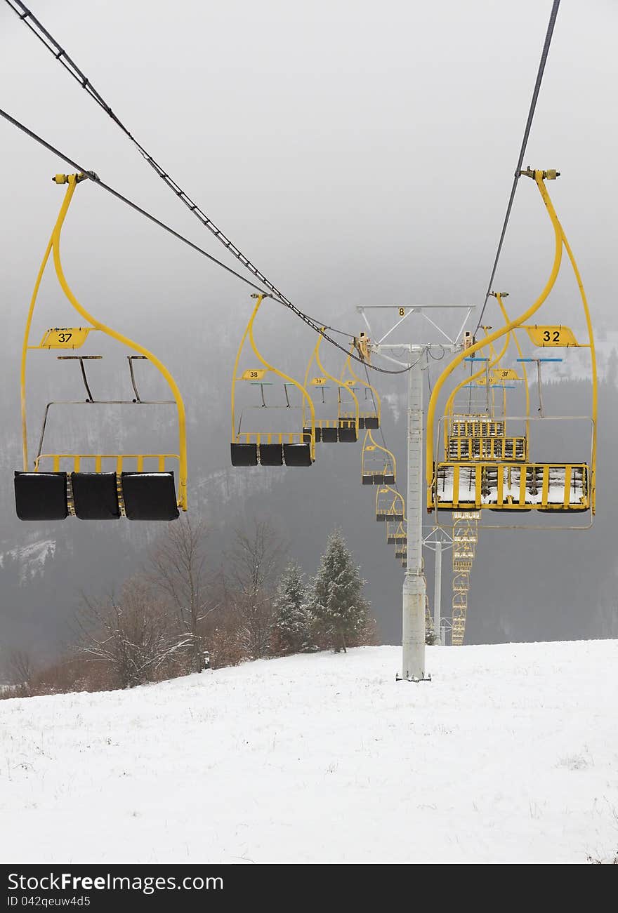 Ski lift chairs on foggy winter day