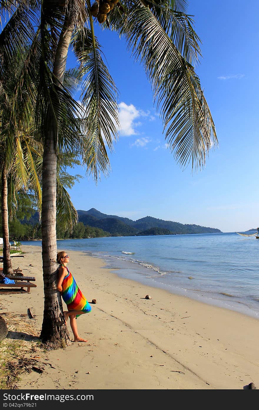 Woman enjoy a moment on tropical beach under palm