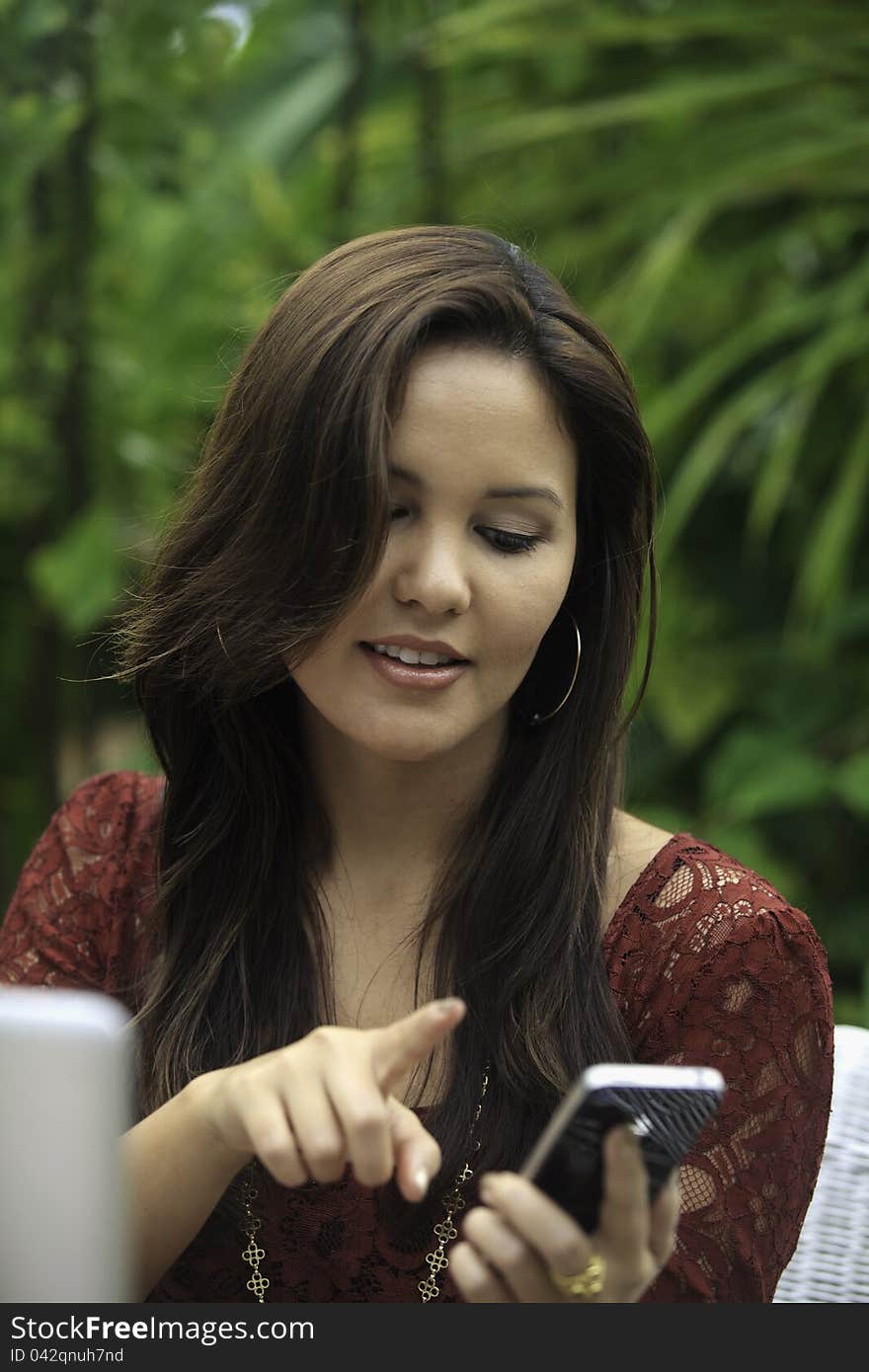 Portrait of a beautiful young woman with her laptop and cell phone outdoors