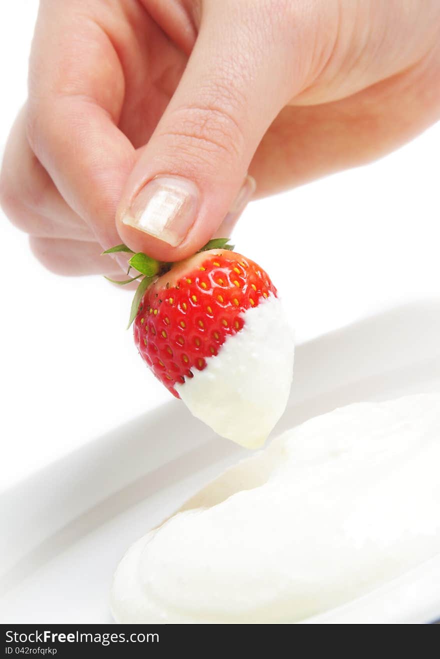 Strawberry in hand with cream over white. Strawberry in hand with cream over white