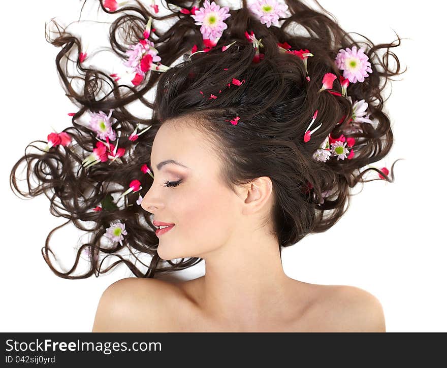 Pretty beautiful girl lying with bright red flowers in her hair bright makeup on white