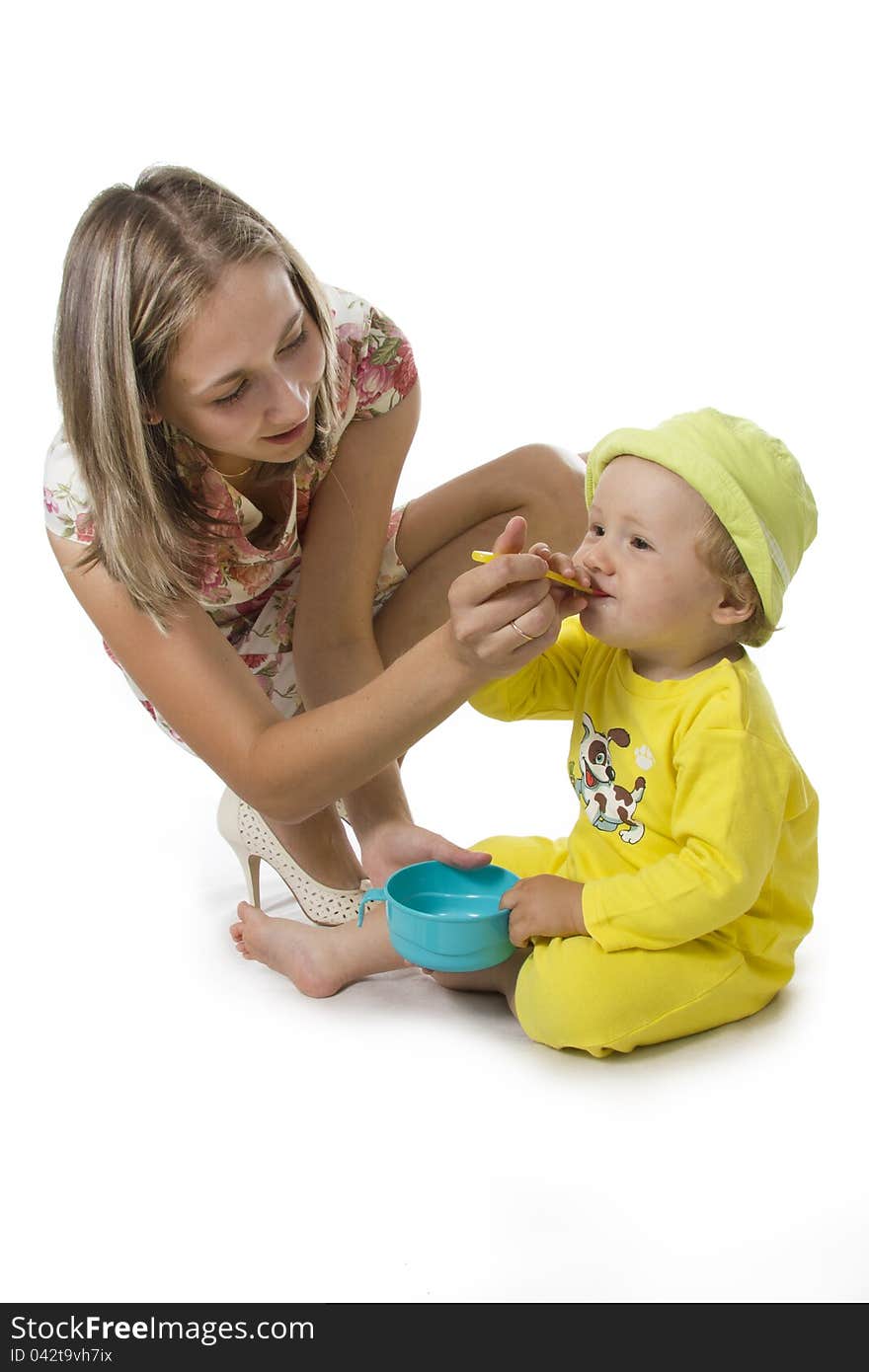 Little boy eating breakfast on white.