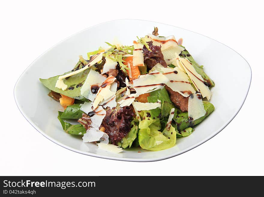 Salad with chicken liver and orange honey dressing in white dish isolated on a white background