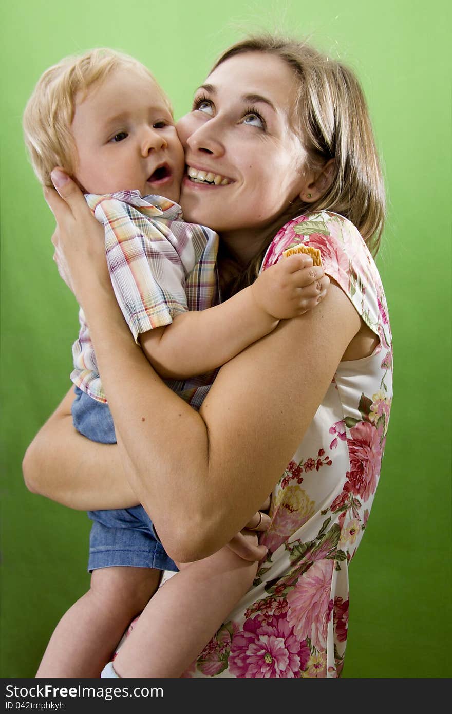 Young happy Mother and its Son isolated on green. Young happy Mother and its Son isolated on green.