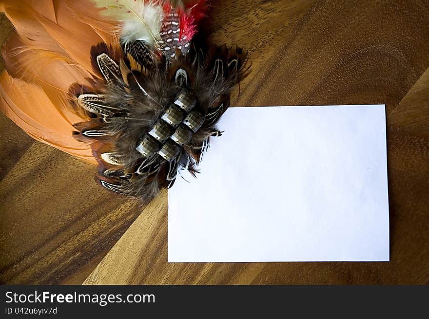 Blank white paper note decorated with orange feathers. Blank white paper note decorated with orange feathers