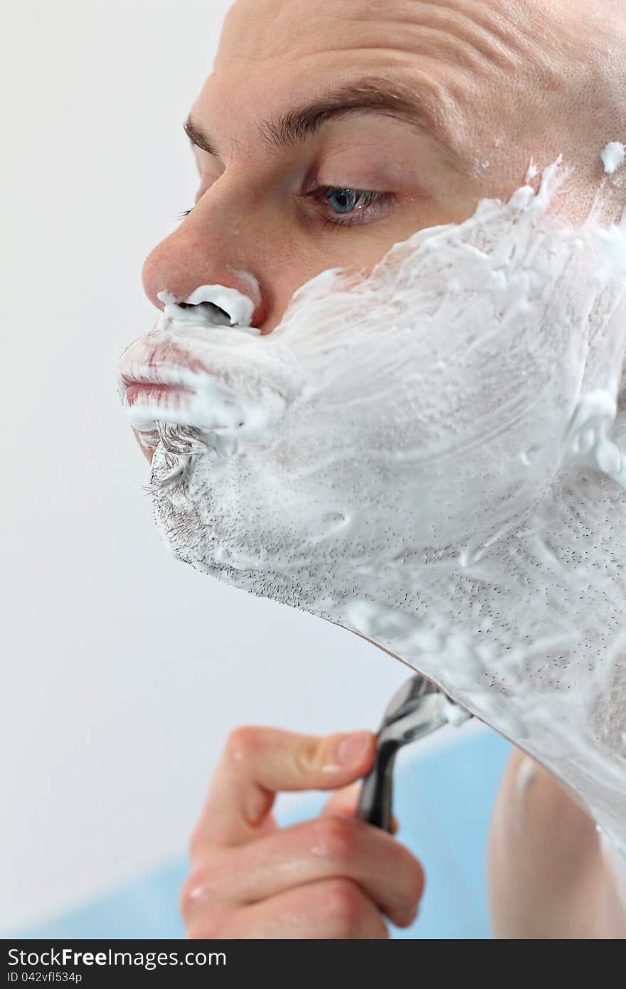 Man shaving his face with razor. Man shaving his face with razor