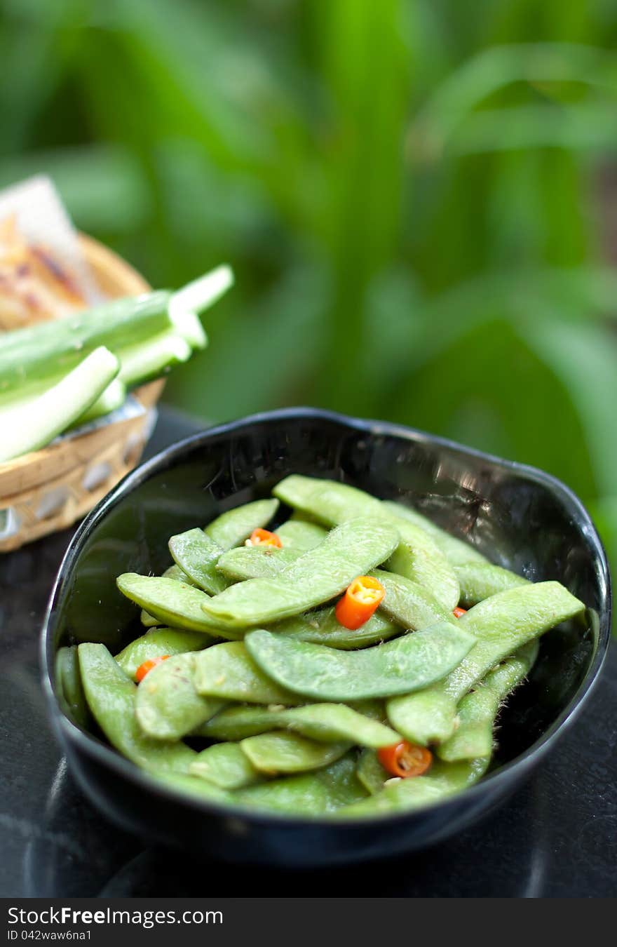 Green beans with red chilli in black ceramic bowl. Green beans with red chilli in black ceramic bowl