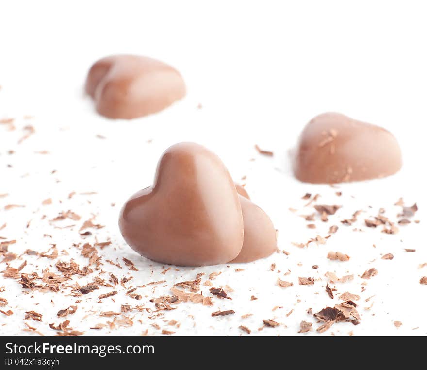 Chocolate hearts and chips on white background.