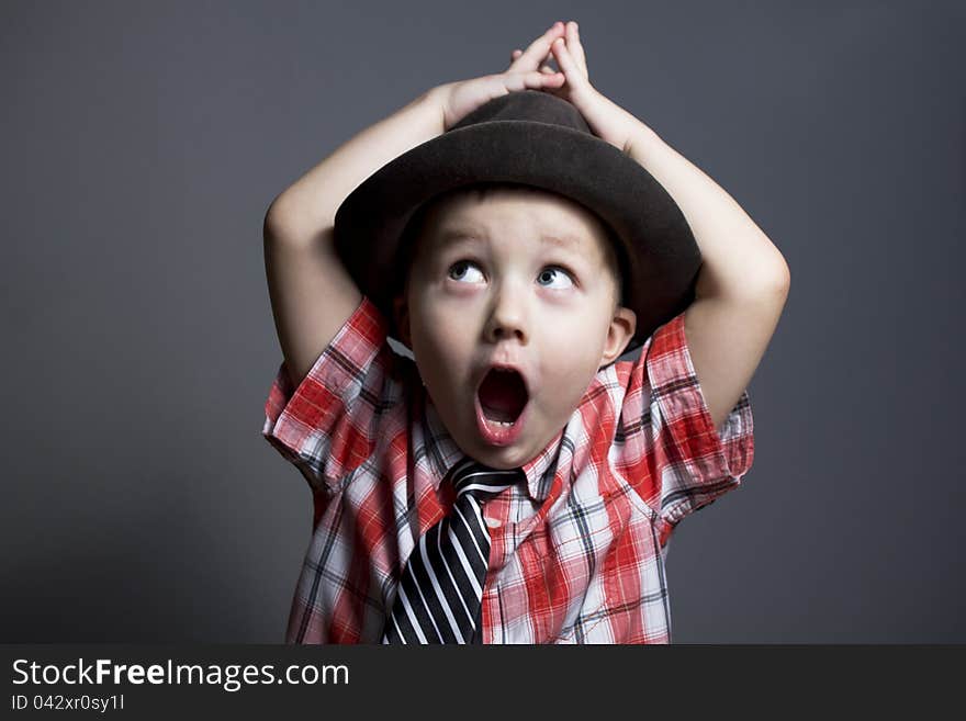 The boy in a hat on a gray background