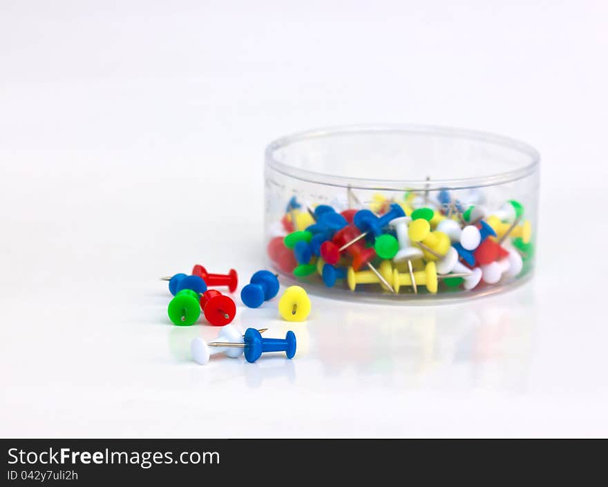 Colored push pins on a white background