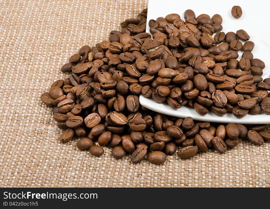 Grains of coffee lie on a saucer