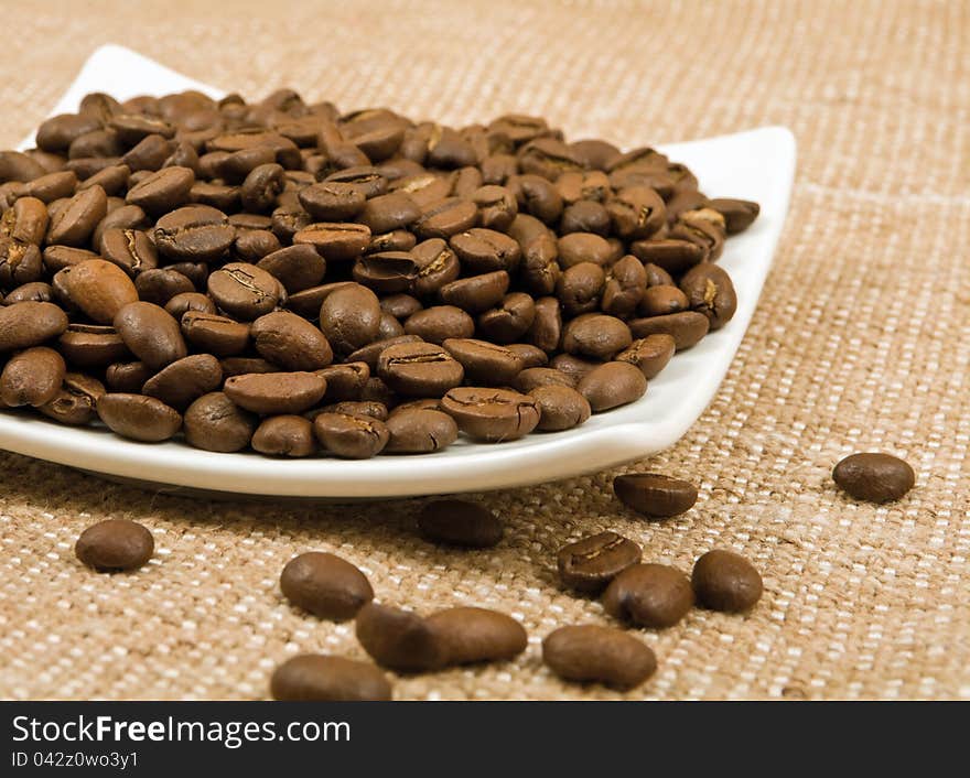 Grains Of Coffee Lie On A Saucer