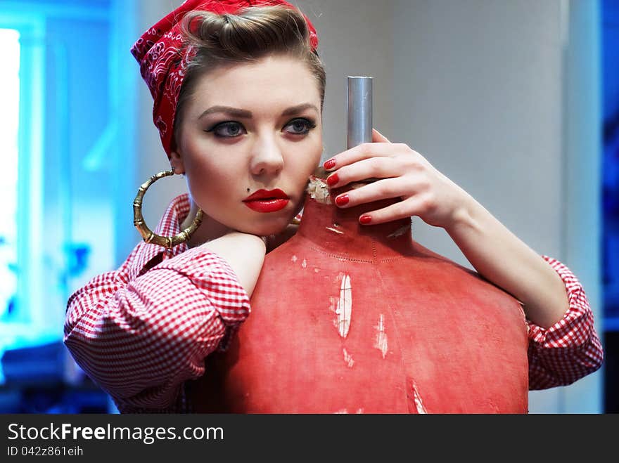 Beautiful and fashion young woman with a pin-up look. posing with a vintage mannequin