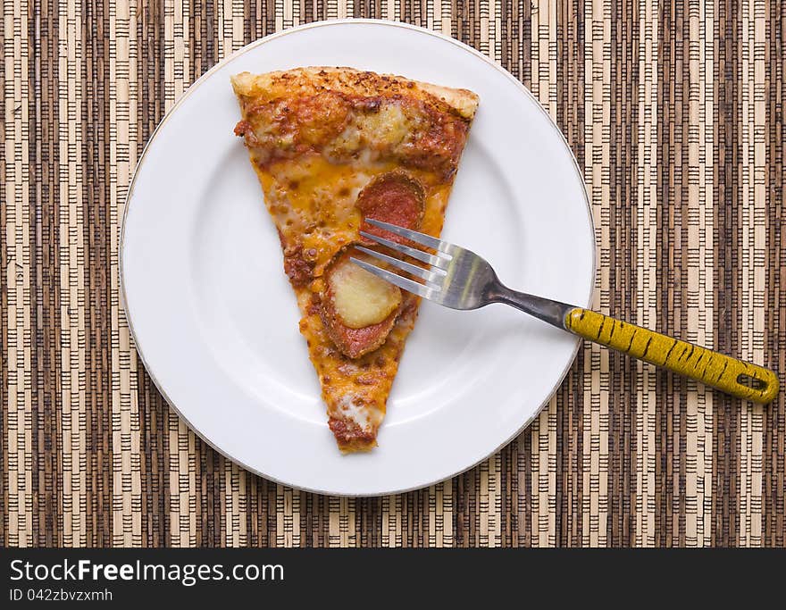 A slice of pizza with fork on white plate, good for your articles