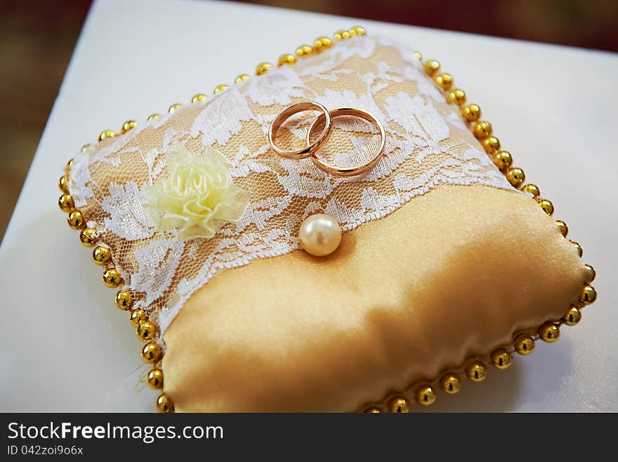 Wedding rings on a satin pillow with lace