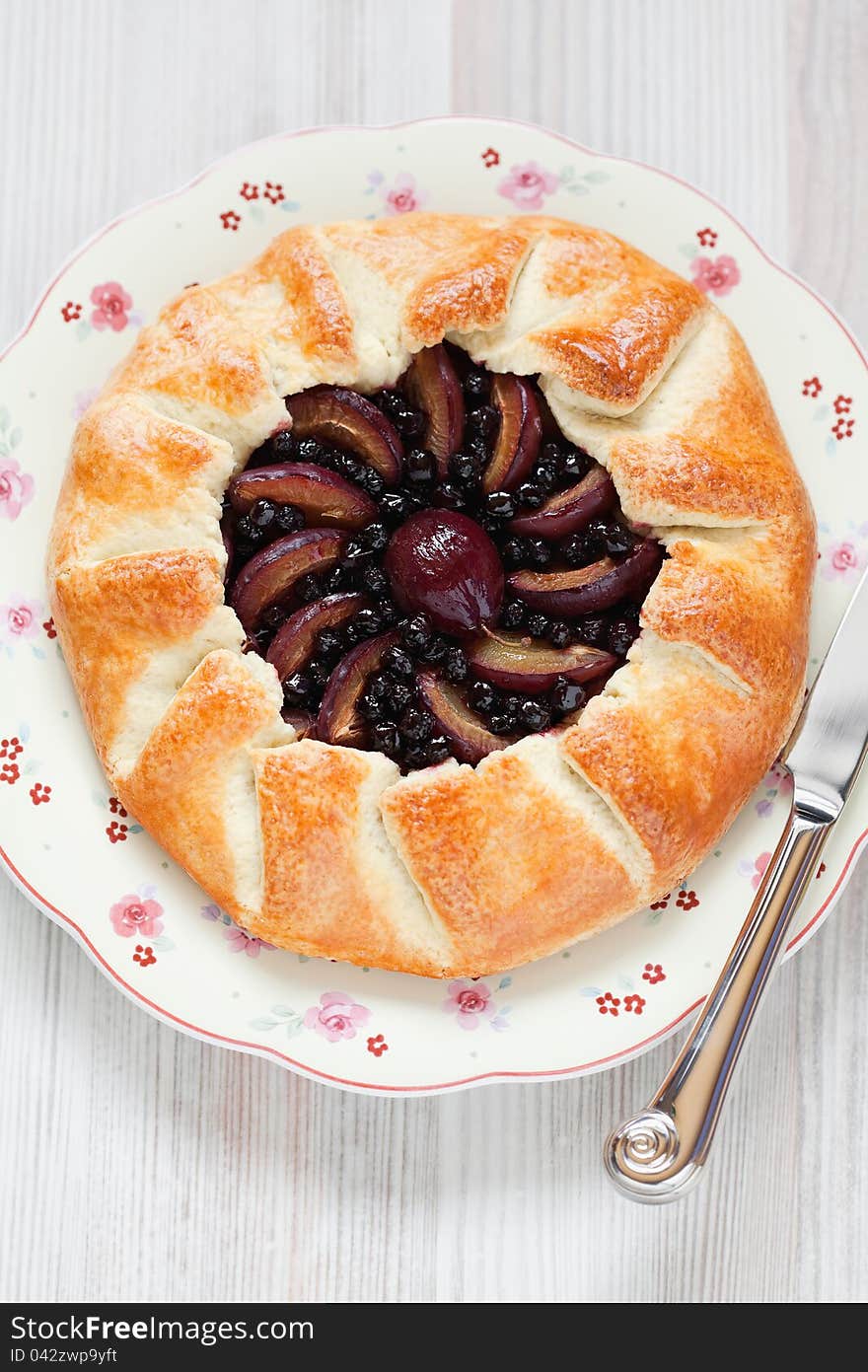 Plum and aronia pie on plate, selective focus. Plum and aronia pie on plate, selective focus