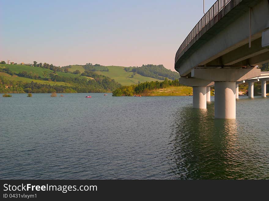 Panoramic sunset landscape lake in Italy and the bridge