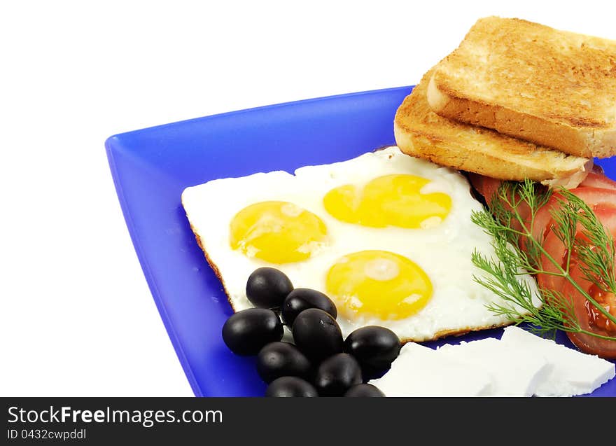 Three fried eggs , olives, cheese and toast on a blue plate. Three fried eggs , olives, cheese and toast on a blue plate