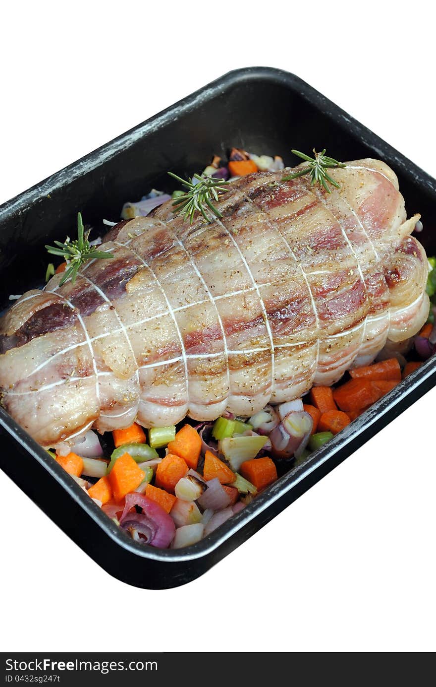 Cooked roast of pork with vegetables in a pan isolated on white. Cooked roast of pork with vegetables in a pan isolated on white