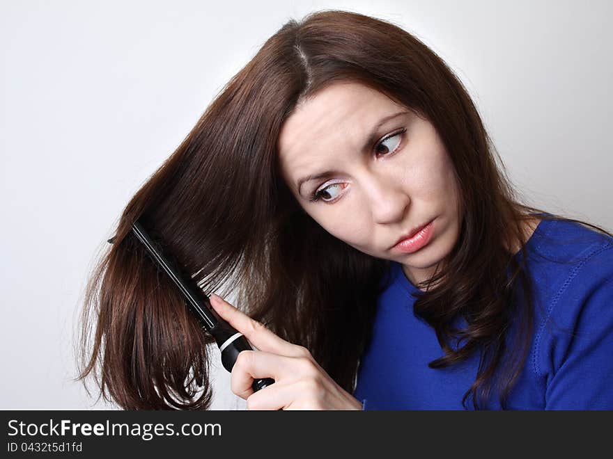 Young woman is struggling to brush her hair. Young woman is struggling to brush her hair