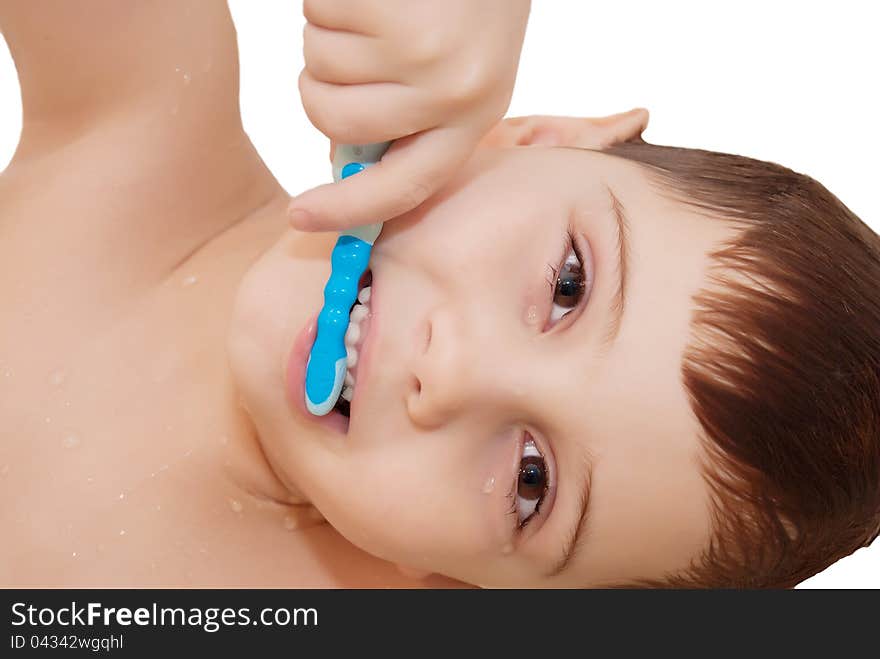 Smiling boy is cleaning his teeth with a nice blue toothbrush isolated on white. Smiling boy is cleaning his teeth with a nice blue toothbrush isolated on white