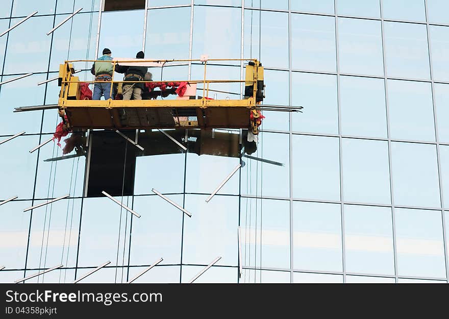 Window washers on a building in downtown. Window washers on a building in downtown