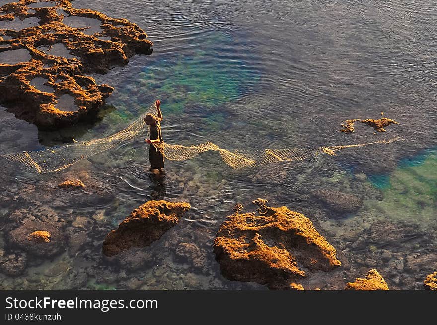 Fisherman at the sea coast with fishing net