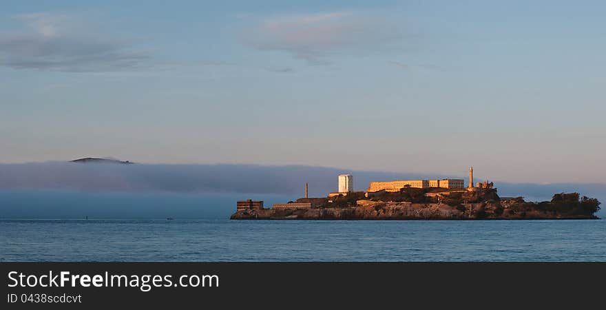 Image of Alcatraz Prison at sunset with fog coming in to San Francisco Bay. Image of Alcatraz Prison at sunset with fog coming in to San Francisco Bay.