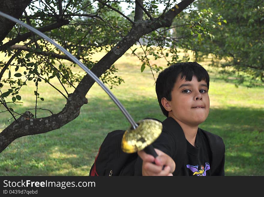 A lovely boy is playing with a sword of toy. A lovely boy is playing with a sword of toy.