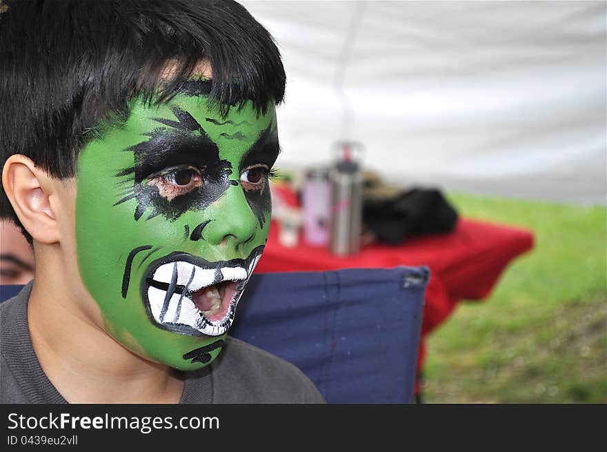 A nice little boy is being shocked. His green painted face has a surprised expression. A nice little boy is being shocked. His green painted face has a surprised expression.