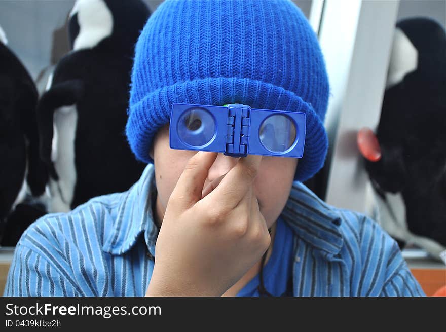 A teenager is using a magnifying glass to explore the world around him. A teenager is using a magnifying glass to explore the world around him.