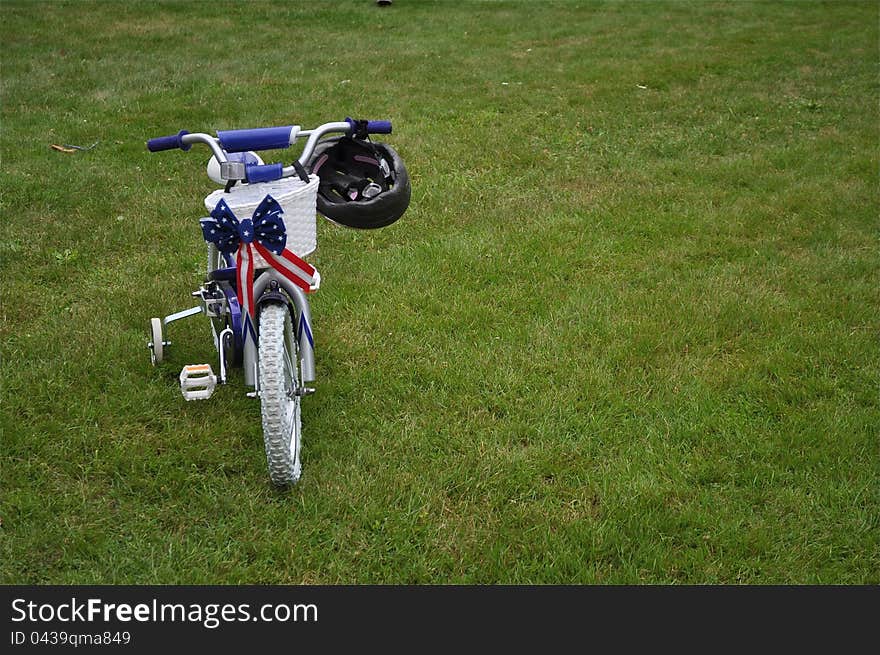 A tricycle is on grass, waiting for its little owner. A tricycle is on grass, waiting for its little owner.