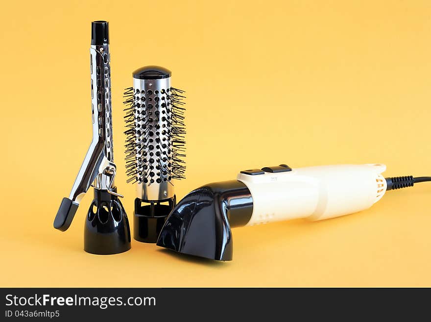 Hairdressing set with various accessories on yellow background