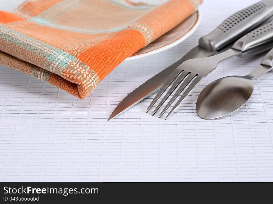 Closeup of cover set near checkered napkin on plate. Closeup of cover set near checkered napkin on plate