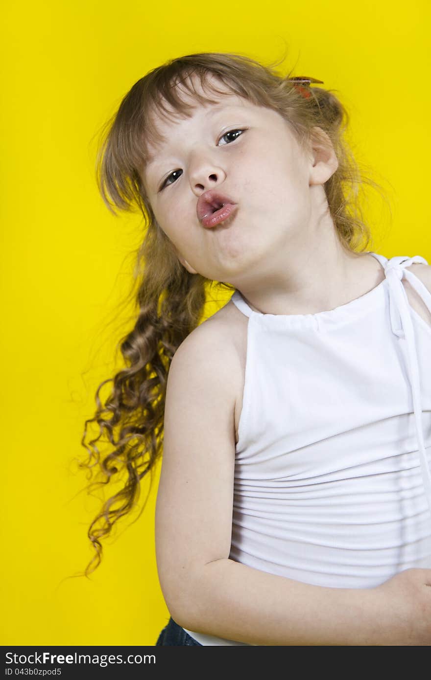 The dancing and singing expressional little girl. On a yellow background. The dancing and singing expressional little girl. On a yellow background