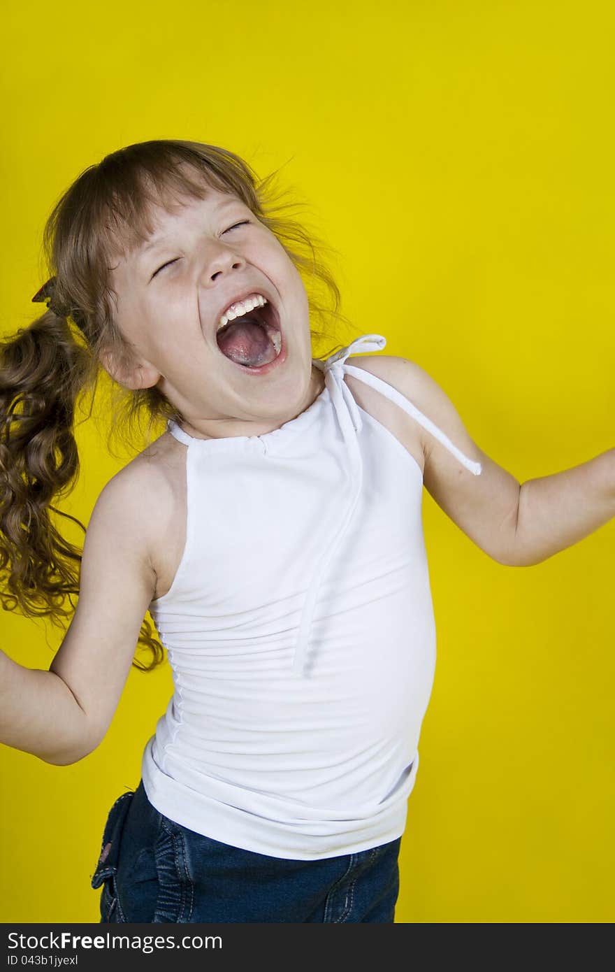 Cheerful Girl Dances On A Yellow Background