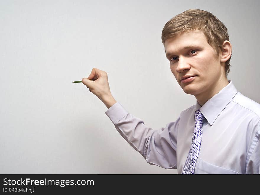 On a gray background business guy holding a pencil