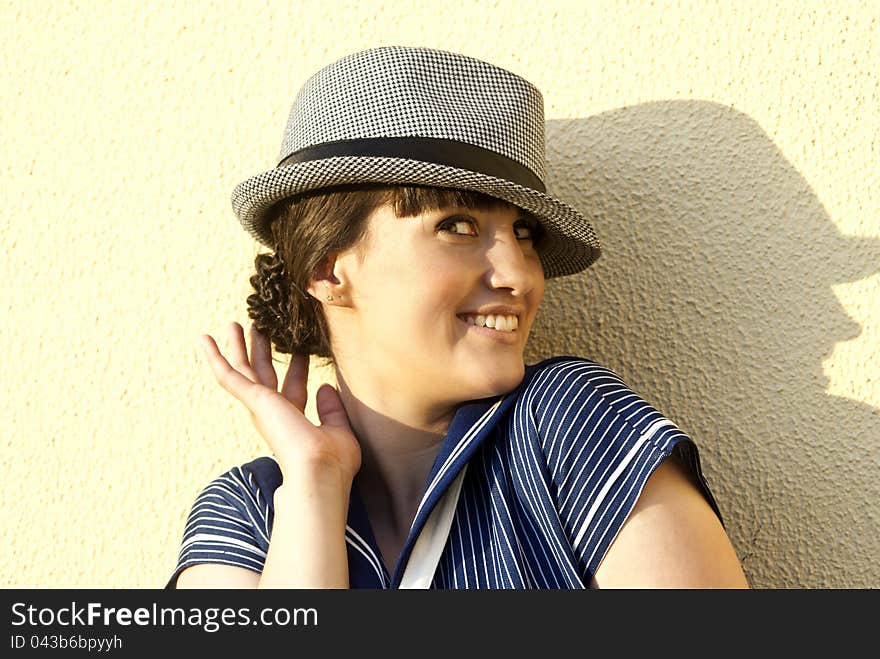 Near The Wall Happy Brunette Girl With Hat