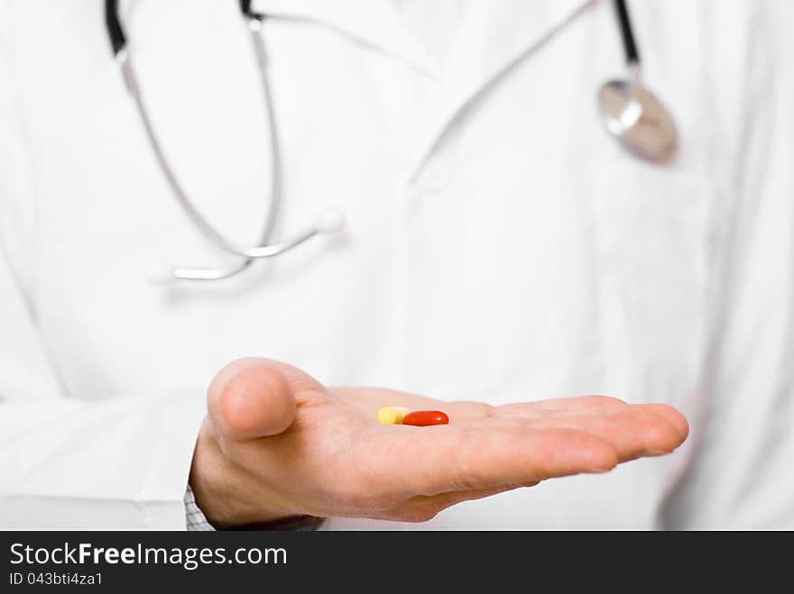 Male doctor showing a pill on his palm. Male doctor showing a pill on his palm