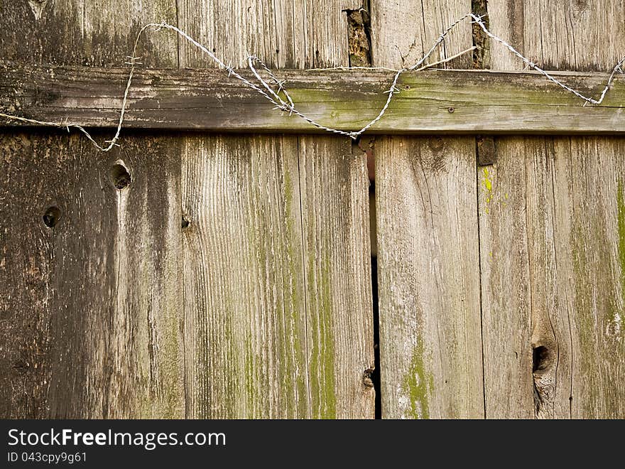 Exterior wood fence with barbed wire.